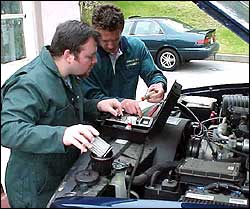 Two men testing oil